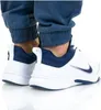 A close-up shot of a person's feet wearing Nike shoes and blue pants. Voir les images du produit