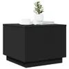 A black side table with a plant, a cup of coffee, and books on top. Voir les images du produit