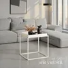 A modern living room scene with a grey sectional sofa and a white side table. Produktbild-Vorschau