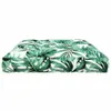 A close-up, side view of a cushion with a green monstera leaf pattern on a white background. Produktbild-Vorschau