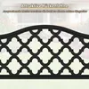 A close-up of a black metal garden bench backrest with an ornate pattern, set against a blurred background of a house and garden. Podgląd zdjęcia produktu