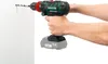 A person is using a cordless drill to drill a hole in a white wall. Produktbild-Vorschau