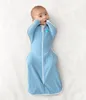 A baby lying on its back, wearing a blue swaddle. Anteprima dell’immagine prodotto