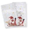 Two clear plastic bags with Christmas-themed designs are shown against a white background. One bag is in the foreground, showing Santa Claus and a reindeer. The other bag is behind it, showing another Santa Claus and a label. Produktbild-Vorschau