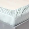 A close-up view of a fitted sheet with a striped pattern. Náhled obrázku produktu
