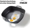 A square frying pan with a speckled interior, showing two fried eggs on a piece of paper inside the pan. The pan has two handles and is shown from a slightly elevated angle. Anteprima dell’immagine prodotto