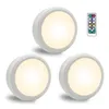 Three white LED puck lights and a remote control are displayed against a white background. Produktbild-Vorschau