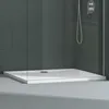 A modern shower tray with a textured surface and a drain, set within a shower enclosure with dark tiled walls and glass panels. Produktbild-Vorschau