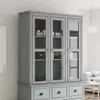 A gray wooden display cabinet with glass doors and drawers, shown in a room setting. Voir les images du produit