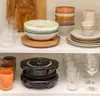 Kitchen shelves with various dishes, bowls, glasses, and a small appliance. Produktbild-Vorschau