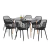 A set of black dining chairs around a black dining table, with bottles of water and fruit on the table. Voir les images du produit