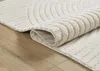 A close-up view of a rolled-up rug with a textured pattern, resting on a wooden floor. Produktbild-Vorschau