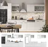 A modern, white, high-gloss kitchen unit with integrated appliances and a marble-effect backsplash, shown in a staged setting with a dining table and chairs. Náhled obrázku produktu