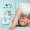 A baby is shown upside down wearing a Pampers diaper, with marketing graphics highlighting product features. Podgląd zdjęcia produktu