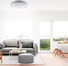 A modern living room with a gray sofa, coffee table, and a large window overlooking a green landscape. Produktbild-Vorschau