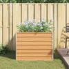 A planter box filled with flowers sits on grass next to a wooden fence and a patio. Anteprima dell’immagine prodotto