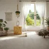 A bright and airy living room with a large window overlooking a garden. Produktbild-Vorschau