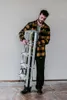A man is holding a folded aluminum ladder indoors, with plastic sheeting on the floor. Anteprima dell’immagine prodotto