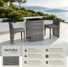 A rattan garden furniture set with a table and two chairs on a patio overlooking a body of water. Produktbild-Vorschau