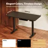A black standing desk is shown in a room with wooden walls and floor. There are color swatches at the bottom of the image. Produktbild-Vorschau