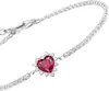 A close-up shot of a silver bracelet with a heart-shaped red gemstone. Podgląd zdjęcia produktu