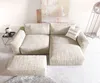 A sectional sofa with an ottoman in a neutral-toned room. Produktbild-Vorschau