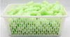 A white plastic basket filled with bright green packing peanuts. Produktbild-Vorschau