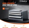 A dark gray metal organizer cabinet with three drawers is shown on a black surface. Text overlays describe the product's features and materials. Produktbild-Vorschau