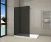 A modern bathroom with a walk-in shower, towel rack, and a large window overlooking a tropical scene. Produktbild-Vorschau