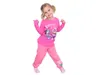 A young girl is posing in a pink outfit against a white background. Produktbild-Vorschau