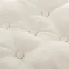 A close-up view of a tufted cushion with visible stitching and buttons. Produktbild-Vorschau