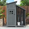 A grey wooden garden shed with an open section displaying garden tools and a bucket, set against a wooden fence and foliage. Produktbild-Vorschau