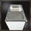 A stainless steel kitchen sink with a draining board is shown mounted on a white cabinet. Náhľad obrázku produktu
