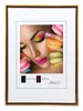 A framed picture of a woman's face with macarons and colorful makeup. Produktbild-Vorschau
