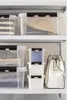 Storage boxes and a handbag are neatly arranged on shelves. Produktbild-Vorschau