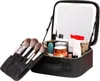 A black makeup travel bag is open, displaying makeup brushes and various cosmetic products inside. The bag has a built-in mirror with LED lights. Anteprima dell’immagine prodotto