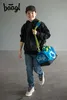 A young boy walks with a sports bag slung over his shoulder. Náhľad obrázku produktu
