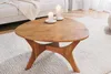 A wooden coffee table with two white candles on it, placed on a white rug in a living room setting. Produktbild-Vorschau