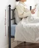 A person is sitting on a bed reading a book, with a measurement scale shown on the side of the bed frame. Podgląd zdjęcia produktu
