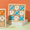 Two wooden tic-tac-toe games are displayed on a white platform against an orange and green background. Náhled obrázku produktu