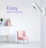 A nursery room setting with a baby monitor mounted on the wall, a small pink chair, and a doll on a cabinet. Produktbild-Vorschau