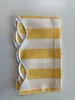 A folded yellow and white striped awning valance with a scalloped edge is shown on a white background. Produktbild-Vorschau