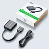 A Ugreen HDMI to VGA converter with its packaging and accessories laid out on a light gray surface. Voir les images du produit