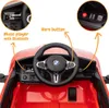Close-up view of the interior of a red children's electric car, focusing on the steering wheel and dashboard. Voir les images du produit