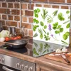 A glass cutting board with various herbs and spices printed on it, placed on a kitchen counter next to a stove. Náhľad obrázku produktu
