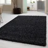 A black shaggy rug is placed on a light-colored floor in a room. Anteprima dell’immagine prodotto