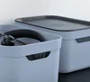 Close-up of two blue storage boxes with lids, one open and one closed. Produktbild-Vorschau