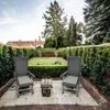 Two chairs and a small table are set up on a patio in a garden, with a manicured lawn and hedges in the background. Podgląd zdjęcia produktu