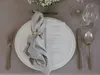 A table setting with a plate, napkin, menu, and cutlery. Produktbild-Vorschau