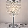 A crystal table lamp with a chrome base sits on a marble surface. Podgląd zdjęcia produktu